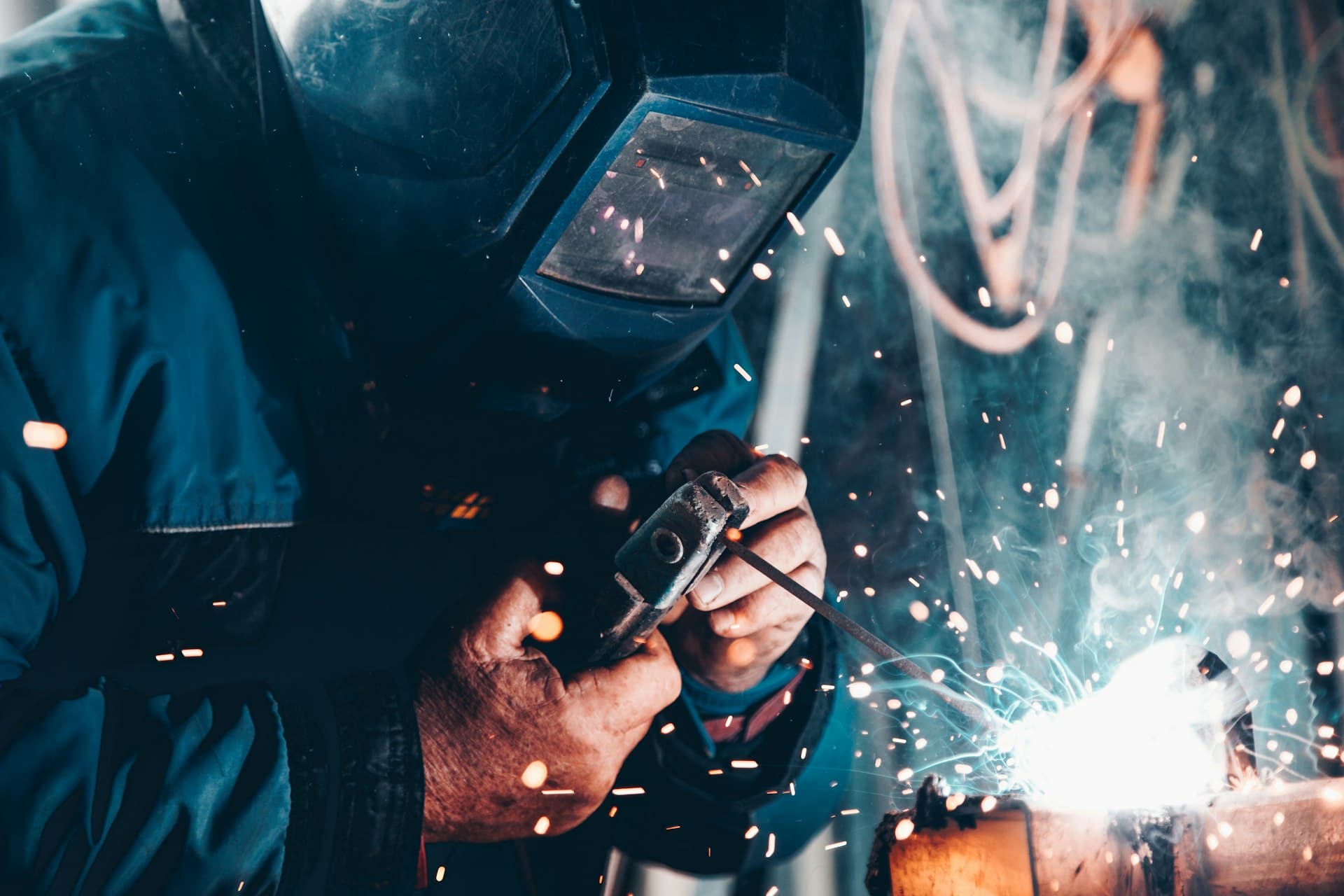 Close-up of a welder at work with sparks and electrode